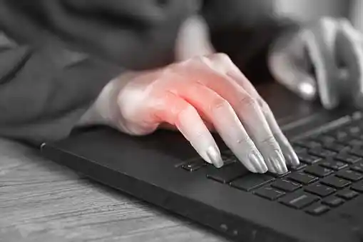 young woman's hand typing, highlighted red color indicating pain due to excessive typing