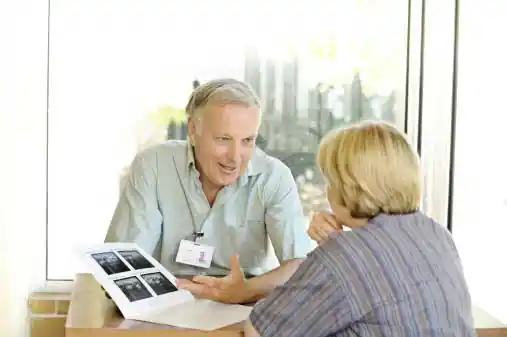 a mature woman talking to a male doctor discussing her x-ray