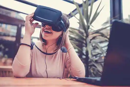 young happy woman playing with her virtual reality glasses