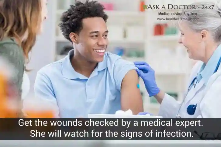  patient and attender getting wound examined by doctor doctor=